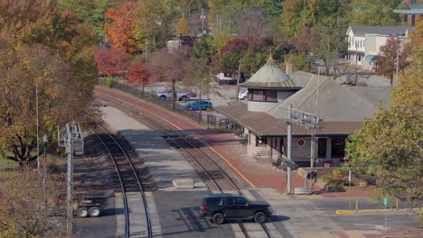 Aerial-of-train-station-and-train-tracks-in-Kirkwood,-Missouri-on-a-beautiful-Fall-day