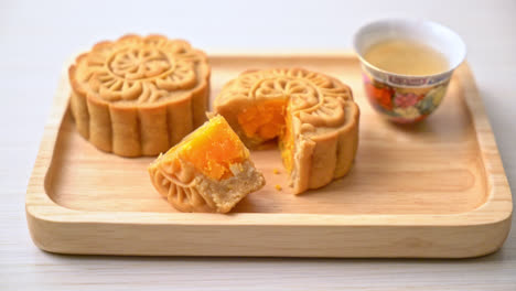 Chinesischer-Mondkuchen-Durian--Und-Eigelbgeschmack-Mit-Tee-Auf-Holzplatte