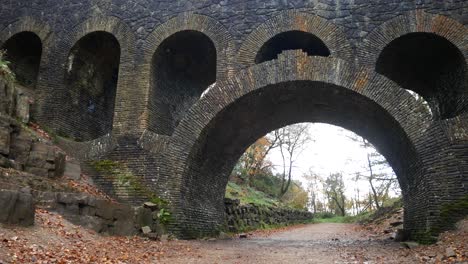 Stone-arched-bridge-ruins-in-Autumn-Rivington-ornamental-woodland-gardens