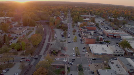 Aerial-of-intersection-at-train-station-in-downtown-Kirkwood,-Missouri-at-sunset-in-the-Fall