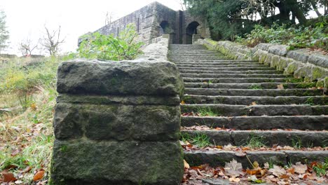 Stone-moss-covered-staircase-ruins-Autumn-woodland-Rivington-ornamental-terraced-gardens-wilderness-slow-dolly-right-looking-up