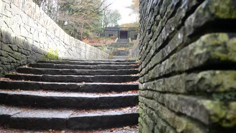 Stone-moss-covered-staircase-ruins-Autumn-woodland-Rivington-ornamental-terraced-gardens-wilderness-dolly-left-from-wall