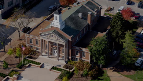 Aerial-of-city-hall-in-Kirkwood,-Missouri-in-Autumn-with-pull-away