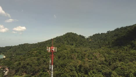 Aerial-shot-of-telecommunications-tower-on-a-tropical-Island-with-jungle-and-ocean