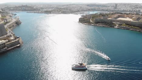 Touristic-boats-sailing-on-pristine-Mediterranean-Sea,-Valletta,-Malta
