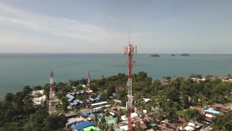 Aerial-orbit-drone-shot-of-telecommunications-tower-on-a-tropical-Island-in-Thailand-with-jungle-and-Islands-and-ocean