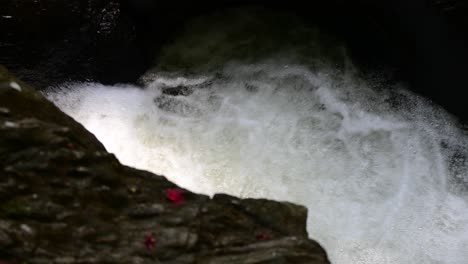 Rapid-water-splashing-in-the-creek,-small-yet-powerful-water-stream-flowing-down-fast-through-rocks