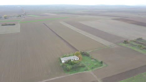 Drone-aerial-flyover-white-farmland-house-in-a-rural-setting-on-misty-morning