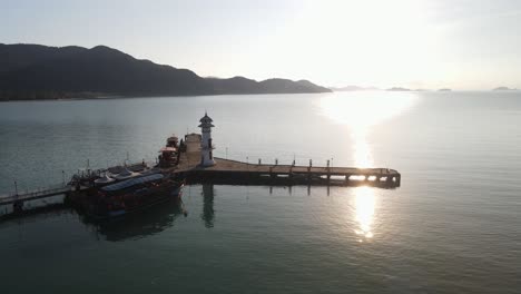 Slow-aerial-orbit-shot-around-a-unique-lighthouse-on-Bang-Bao-pier-at-sunset-in-Koh-Chang,-Thailand