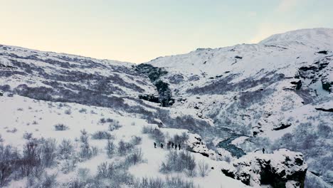 Leute,-Die-Während-Der-Wintersaison-Auf-Kalten-Schneebedeckten-Bergen-In-Island-Wandern---Luftdrohne