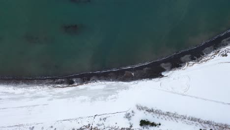 Türkisblaues-Meer-Und-Küste-Mit-Weißem-Schnee-Bedeckt---Malerische-Aussicht-Von-Oben-In-Island---Top-Down-Drohne
