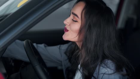 Beautiful-woman-fascinatingly-evaluates-the-car-behind-the-wheel