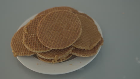 Top-down-dolly-of-pile-of-stroopwafels-on-white-plate