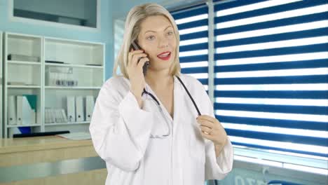 Una-Doctora-Está-Hablando-Por-Su-Teléfono-Celular-En-La-Oficina-De-Recepción-De-Cirugía-De-Los-Médicos