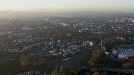Drohnenaufnahme-Der-Stadtlandschaft-Von-Kassel-In-Schönem,-Weichem-Sonnenlicht-Und-Mit-Nebel-Bedeckt