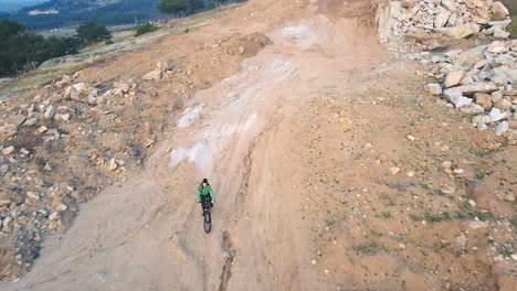 Girl-riding-a-mountain-bike-downhill-on-a-rough-terrain