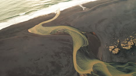 Gelbe-Flussmündung-Am-Schwarzen-Sandstrand---Luftaufnahmen-Von-Island