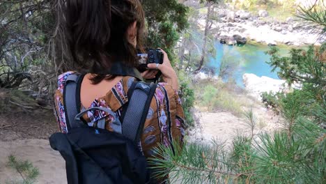 Female-young-caucasian-photographer-taking-photo-front-to-river-In-Patagonia-Argentina