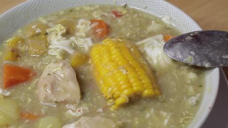 bowl-of-seasoned-soup-with-shredded-chicken,-egg-and-corn-in-the-center,-healthy-living-concept-at-home