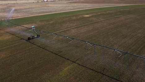 Central-pivot-irrigation-system-in-full-operations-with-end-cap-sprinkler-and-multi-sprayers-underneath
