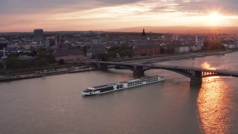 Redish-sunset-over-Mainz-on-a-warm-Spring-day-2021-with-a-ship-on-the-Rhine-river-and-sun-reflections-on-the-water