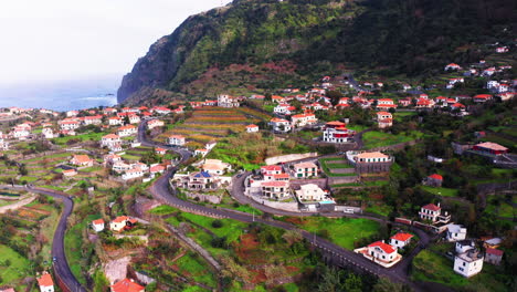 Low-aerial-shot-of-Ponta-Delgada-with-houses-and-apartments-surrounded-by-green-grass-fields-and-roads