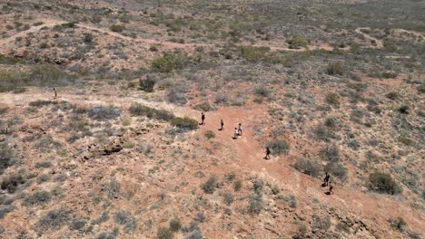 Group-of-people-walking-through-australian-desert-In-Exmouth,-Western-Australia