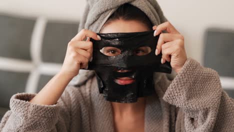 Beautiful-charismatic-girl-wears-a-black-cosmetic-mask-on-her-face