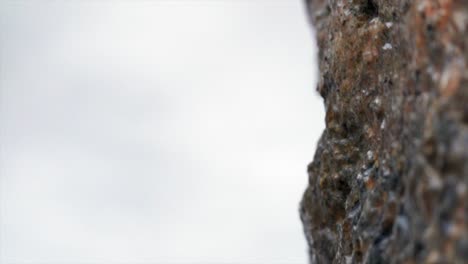 Snow-falling-on-old-stone-megalithic-rock-dolmen,-outdoors-macro-closeup