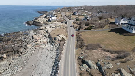 Aerial-Drone-footage-of-coastal-community-on-the-Atlantic-in-Cohasset,-MA,-Drone-follows-the-road-next-to-coastline