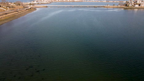 Aerial-drone-footage-approaching-bridge-that-connects-mainland-to-Spinnaker-Island-in-Hull-Bay,-Hull,-MA