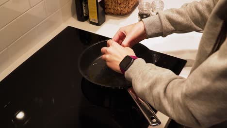 Woman-hands-break-egg-and-cooking-the-scrambled-eggs-on-the-frying-pan
