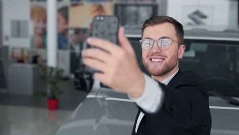 Hombre-Guapo-Con-Gafas-Tomando-Selfie-Con-Coche-En-El-Teléfono