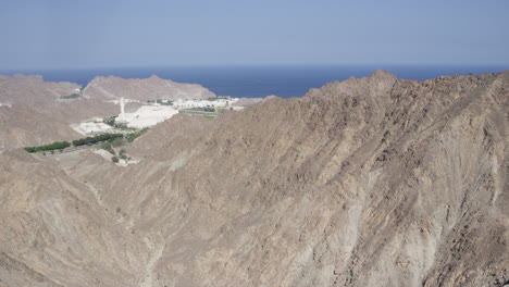Port-Sultan-Qaboos-and-the-Al-Hajar-Mountains-in-Muscat,-Oman,-wide-shot