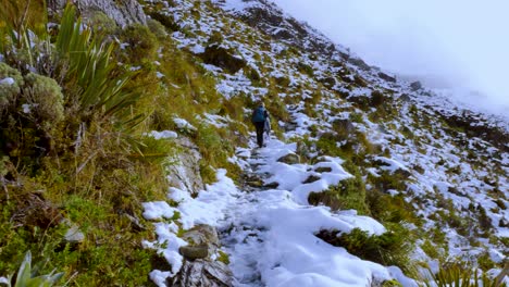 Solo-trekker,-hiking-the-snow-covered-steep-slopes-of-mountains