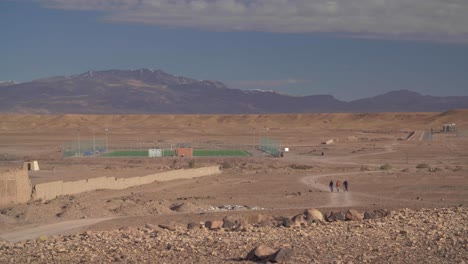 Un-Campo-De-Fútbol-En-Medio-Del-Desierto-En-Ouarzazate-Con-Vistas-A-Las-Montañas-Nevadas