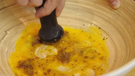 Mashing-ingredients-for-caesar-salad-sauce-inside-deep-cooking-bowl