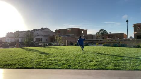 Boy-running-on-grass-with-paper-airplane-in-hand