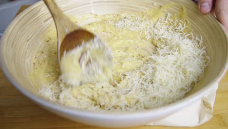 Mixing-cheese-with-caesar-salad-sauce-inside-deep-cooking-bowl