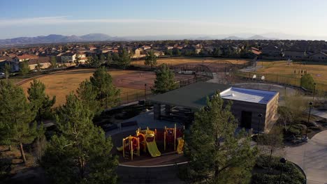 Descending-aerial-shot-of-children-playing-on-playground-in-a-master-planned-community-in-the-desert