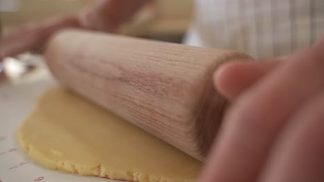 A-baker-rolling-out-pastry-dough-with-a-wooden-rolling-pin