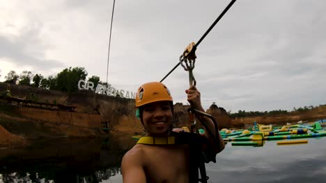 Tourist-Ziplining-In-The-Grand-Canyon-Water-Park-In-Chiang-Mai,-Thailand---selfie-shot