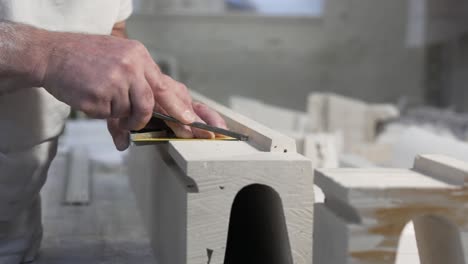 Craftsman-hands-working-with-gypsum-piece-in-his-workshop