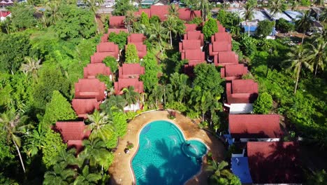 Drone-footage:-Luxurious-Swimming-Pool-in-the-Jungle-Hotel-with-red-roofs-on-Koh-Chang,-Thailand,-Asia
