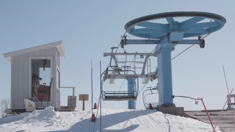 Empty-ski-chairlift-in-operation-on-top-of-snowy-mountain,-slow-motion