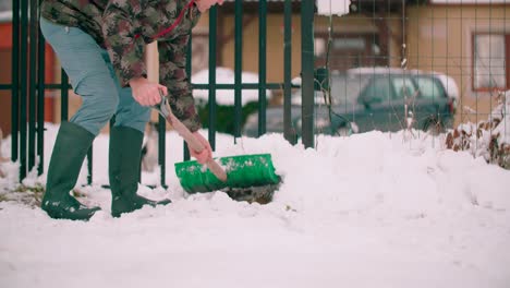 Man-with-a-shovel-in-his-hands-moving-a-pile-of-snow