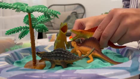 Kind-Spielt-Mit-Mini-Spielzeug-Dinosaurierfiguren