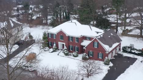 Large-colonial-brick-home-covered-in-winter-snow