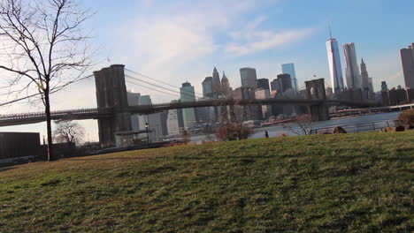 Brooklyn-Bridge,-Freedom-Tower-Manhattan-Skyline,-Wide-Shot,-Cars-and-Woman-Walking-Dog