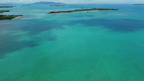 Slow-aerial-tilt-up-over-pristine-waters,-islands-near-Boat-Pass,-new-Caledonia